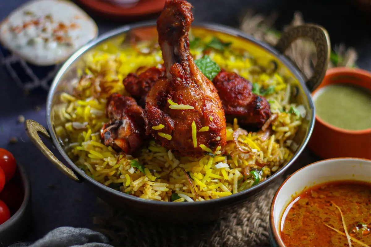 Washing yellow rice in a sieve under running water to remove excess starch and impurities.